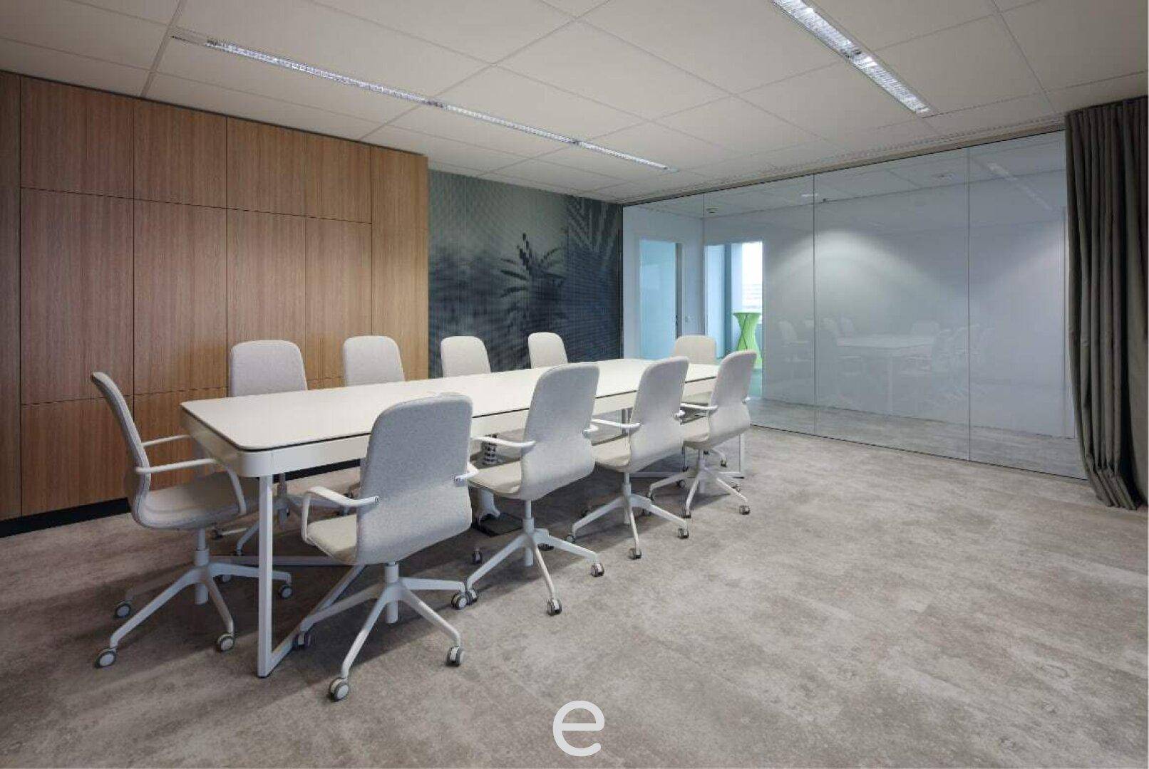 Moderner Konferenzraum mit Holzwandverkleidung, großem Tisch und bequemen Stühlen, abgetrennt durch Glaswände.