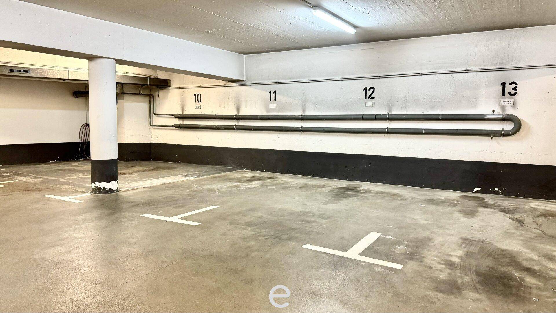 Innenansicht einer Tiefgarage mit nummerierten Stellplätzen und einem robusten Betonboden.