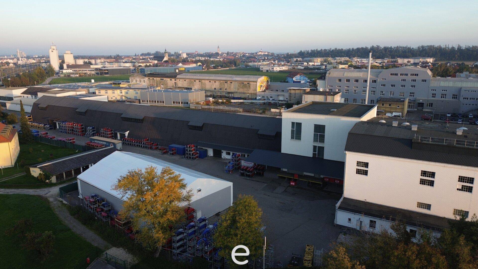 Weitläufige Luftaufnahme eines Industriegebiets mit Blick auf eine nahegelegene Stadt und Landschaft.