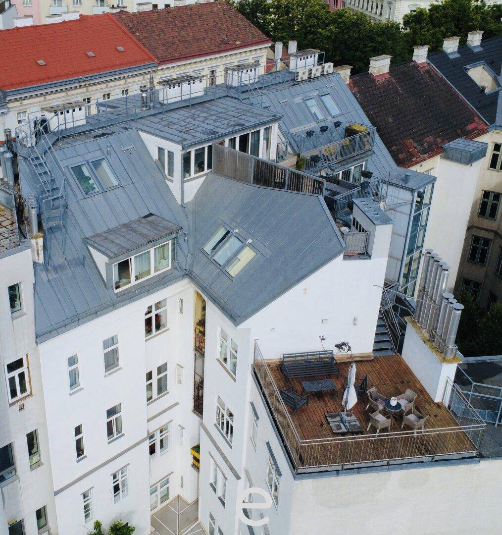 Luftaufnahme eines Innenhofs mit mehreren Dachterrassen und einem möblierten Außenbereich.
