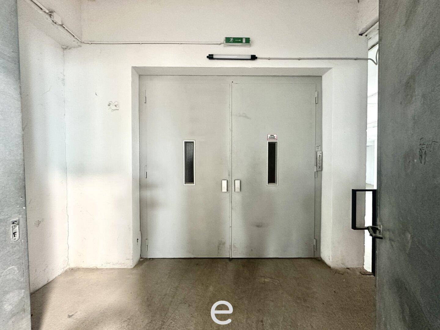 Große Doppeltüren eines Lastenaufzugs in einem Industriegebäude, bereit für schwere Lasten.