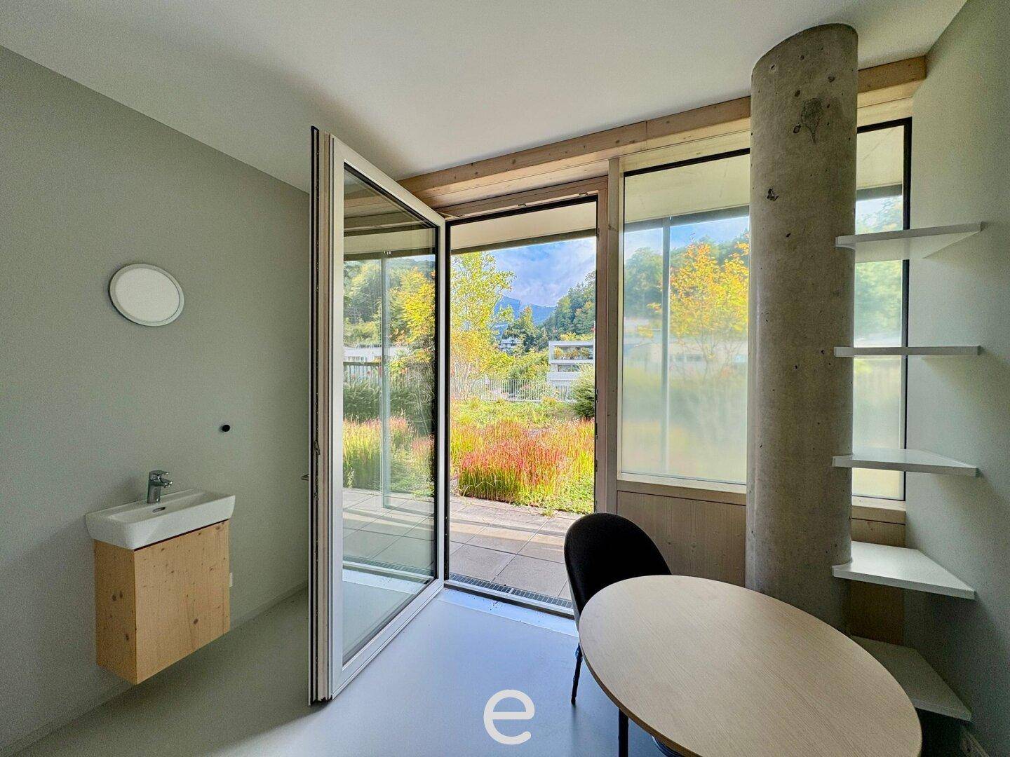 Geräumiges Büro mit Zugang zur Dachterrasse, viel Tageslicht und einem modernen Waschbecken.