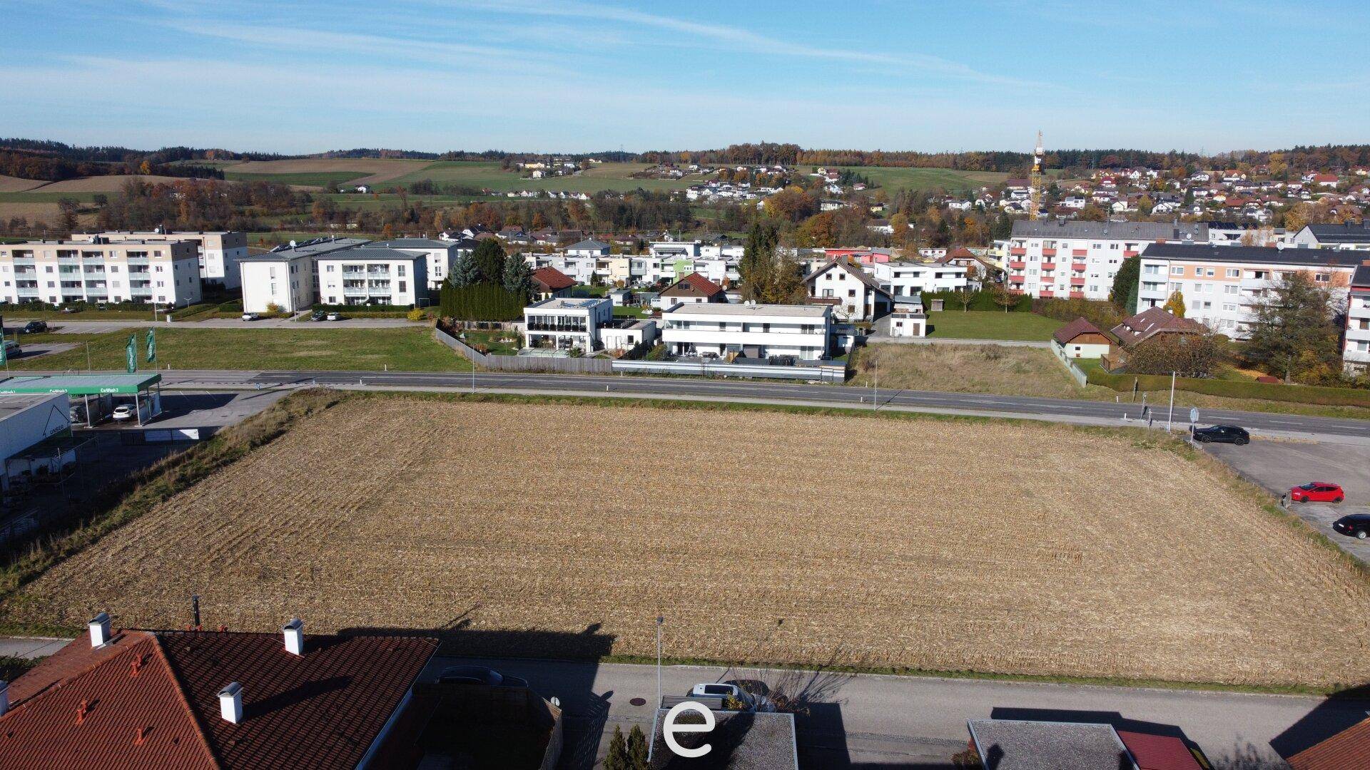 Übersicht aus der Vogelperspektive des unbebauten Grundstücks mit angrenzenden Gebäuden und hügeliger Landschaft.