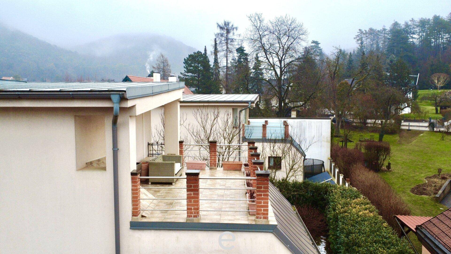 Dachterrasse mit Sitzgelegenheiten und weitem Blick auf die grüne Umgebung.
