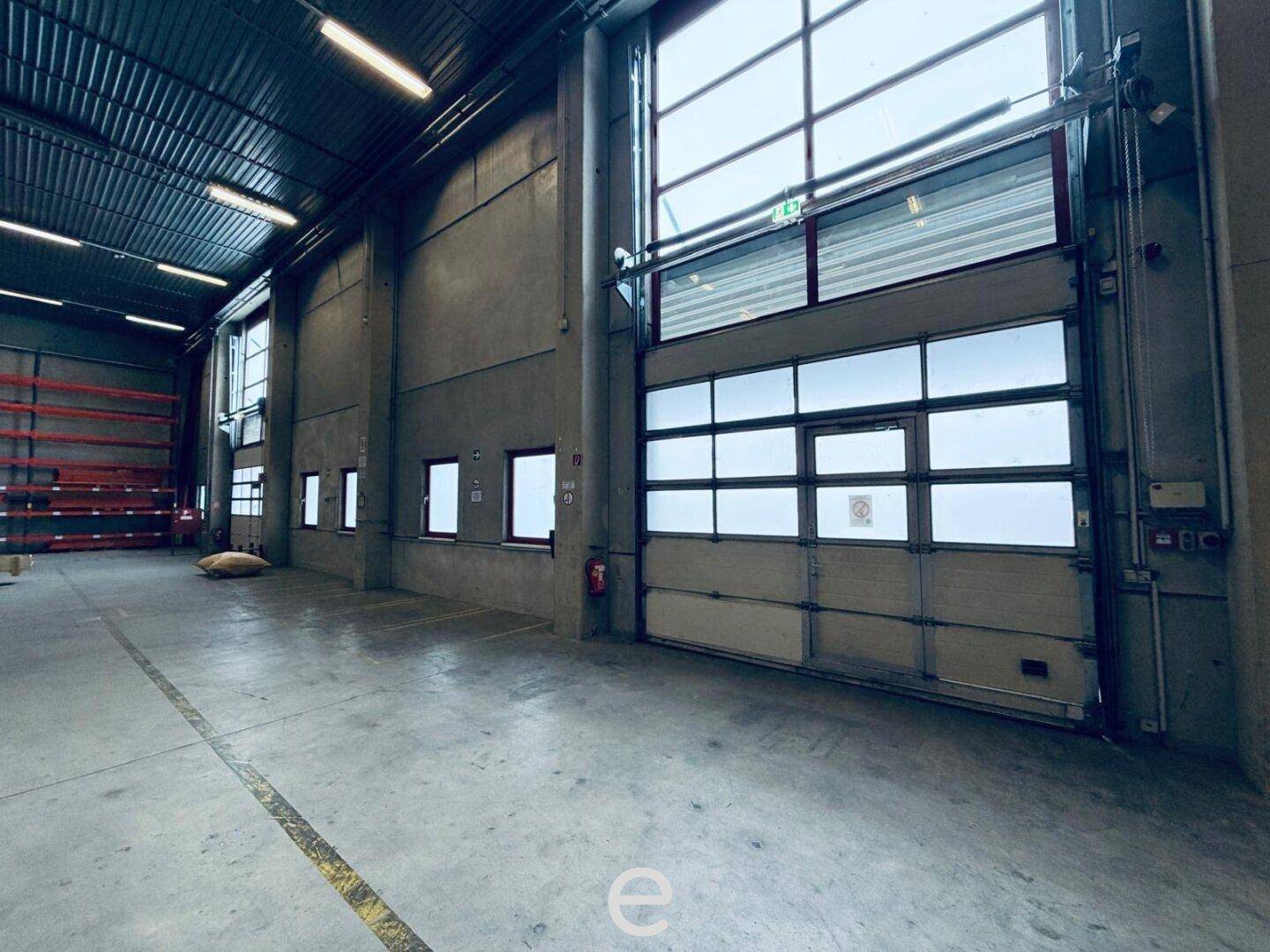 Innenansicht einer Laderampe mit großem Rolltor und Zugang zum Lagerbereich, ideal für Logistik.