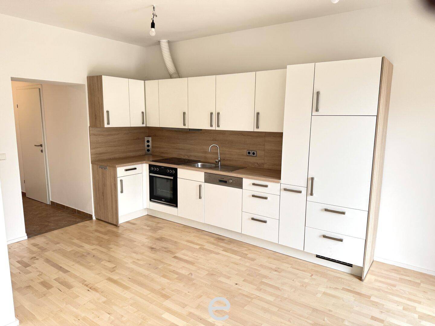 Moderne Einbauküche mit hellen Fronten, Holzoptik-Arbeitsplatten und integrierten Geräten.