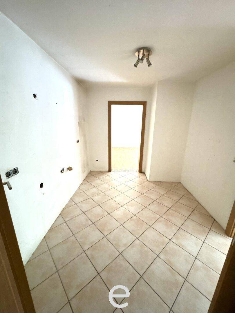 Kleiner Raum mit Fliesenboden und weißen Wänden, vorbereitet für individuelle Gestaltung.
