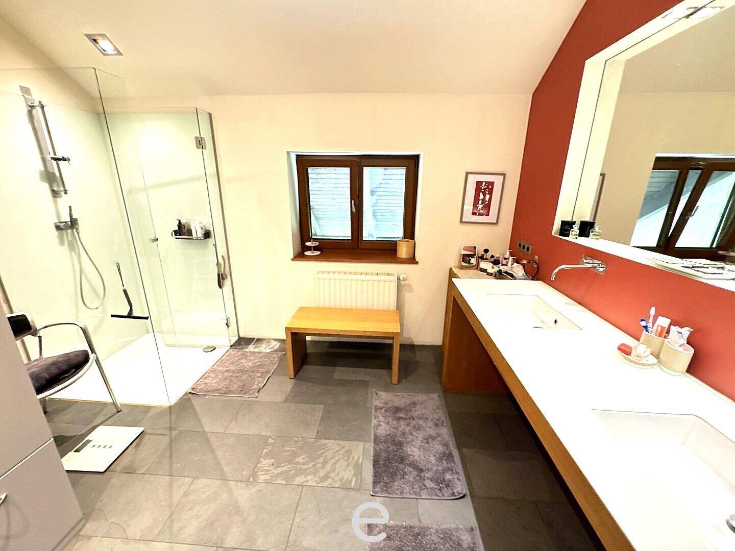 Modernes Badezimmer mit begehbarer Dusche, Doppelwaschbecken und großformatigen Fliesen.