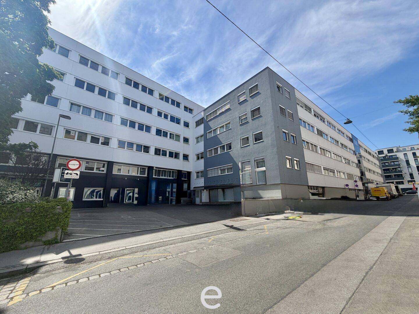 Außenansicht eines großen Bürogebäudes mit vielen Fenstern und moderner Architektur.