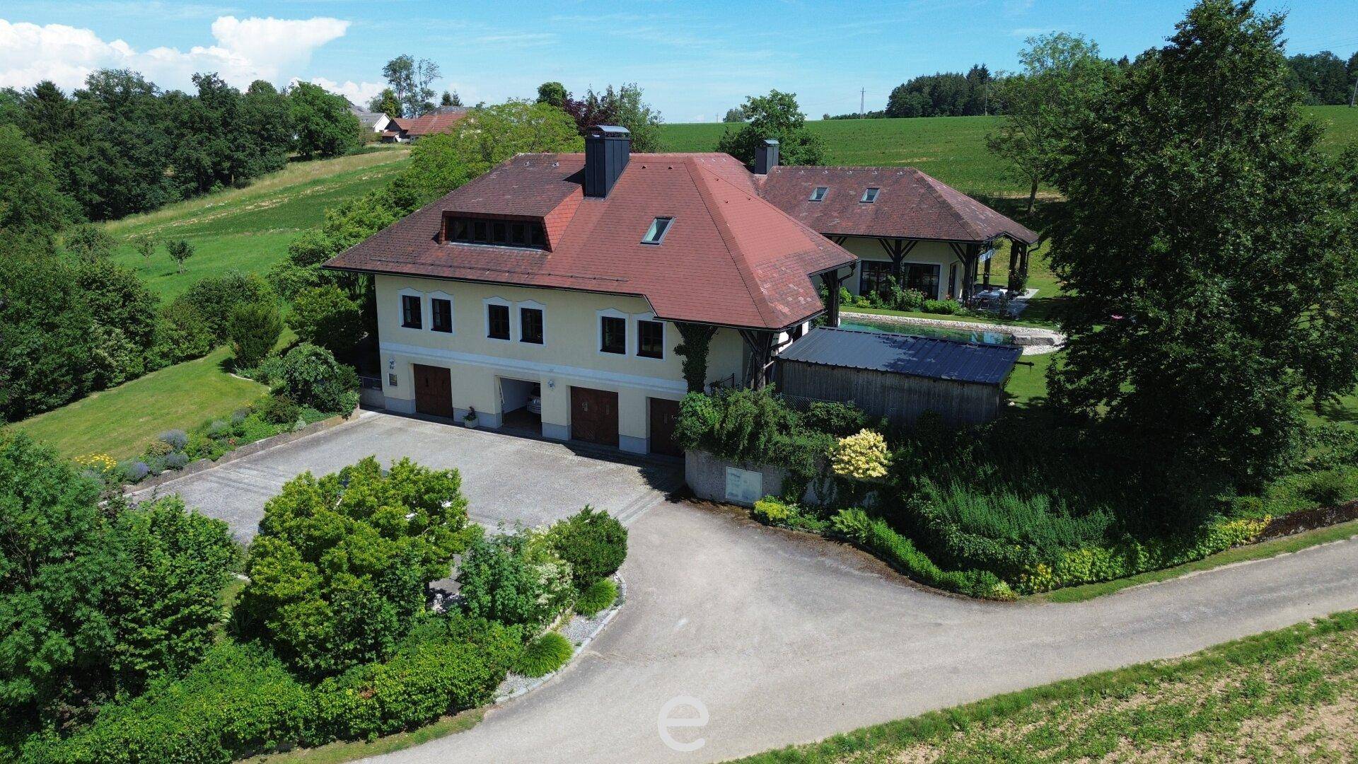 Weitläufige Auffahrt zum Anwesen mit Doppelgarage und umgebender ländlicher Idylle.