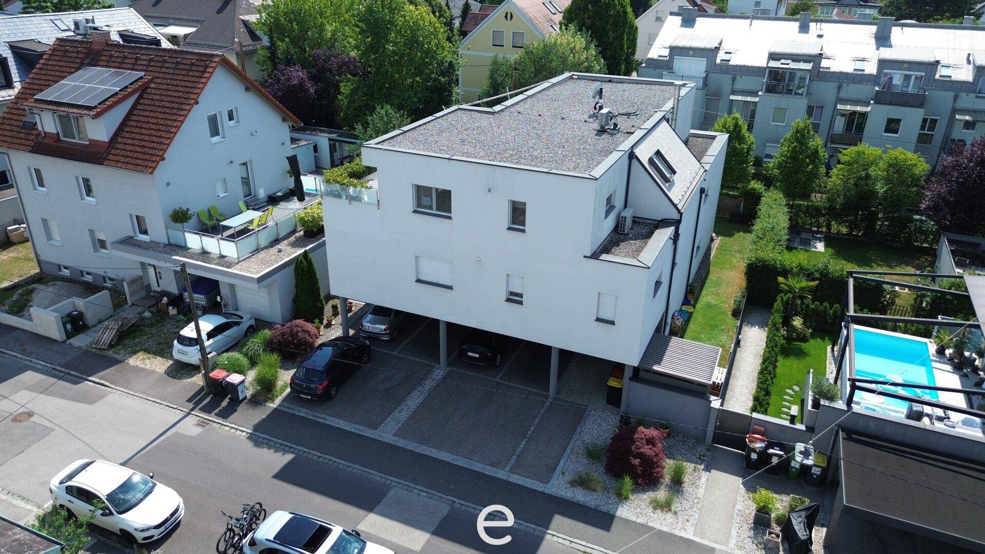 Ansicht des modernen Wohnhauses von der Straßenseite mit überdachten Stellplätzen.