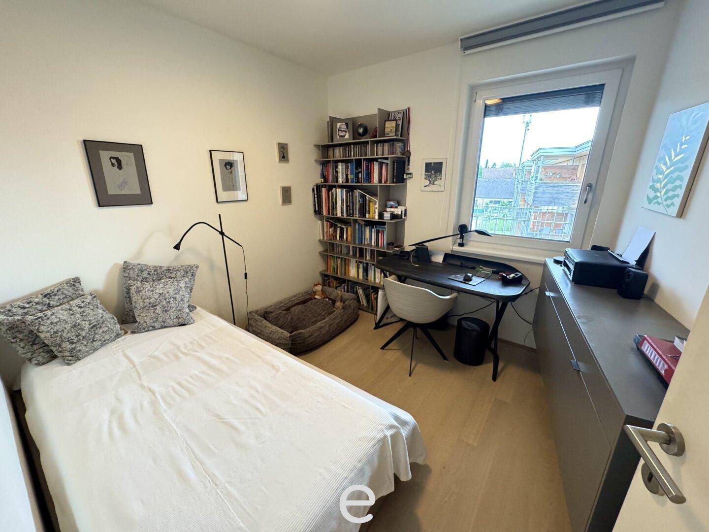 Gemütliches Zimmer mit Einzelbett, Schreibtisch und Bücherregal, ideal als Gäste- oder Arbeitszimmer.
