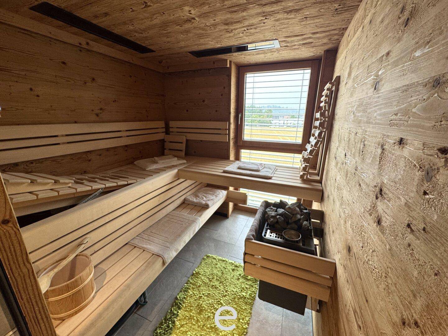 Private Holzsauna mit bequemen Bänken und Fenster, ideal zur Entspannung nach einem langen Tag.