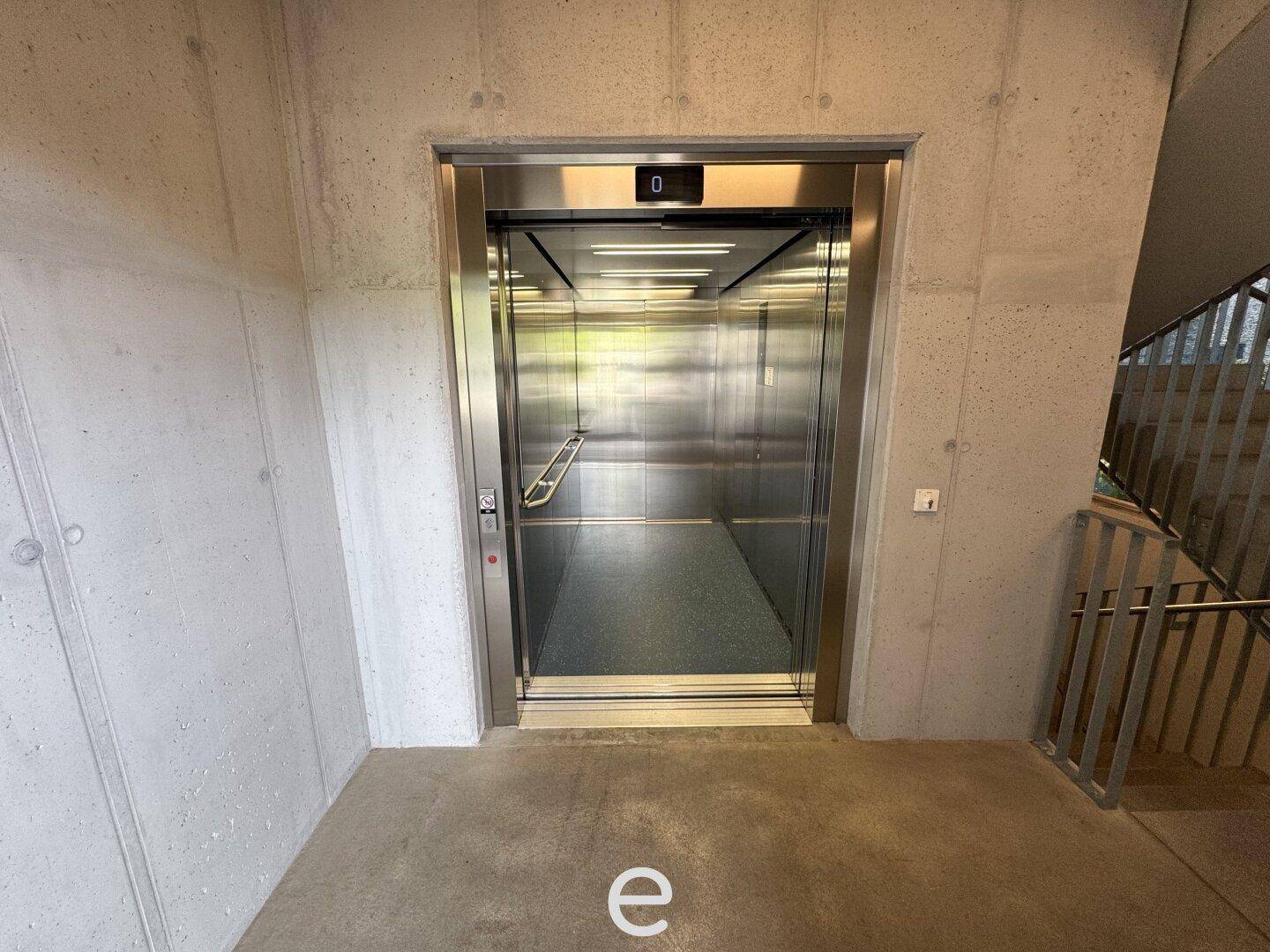 Moderner Aufzug in einem Betongebäude, der barrierefreien Zugang zu allen Etagen bietet.