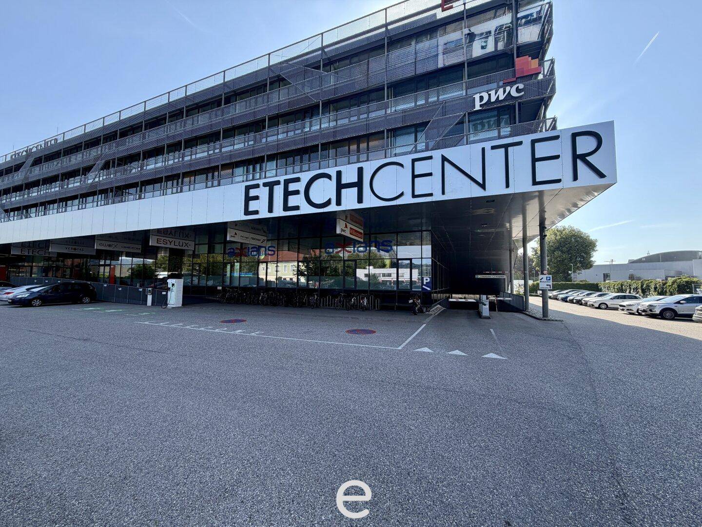 Ansicht des Erdgeschosses des ETECHCENTER-Gebäudes mit modernem Eingangsbereich und Parkplätzen.