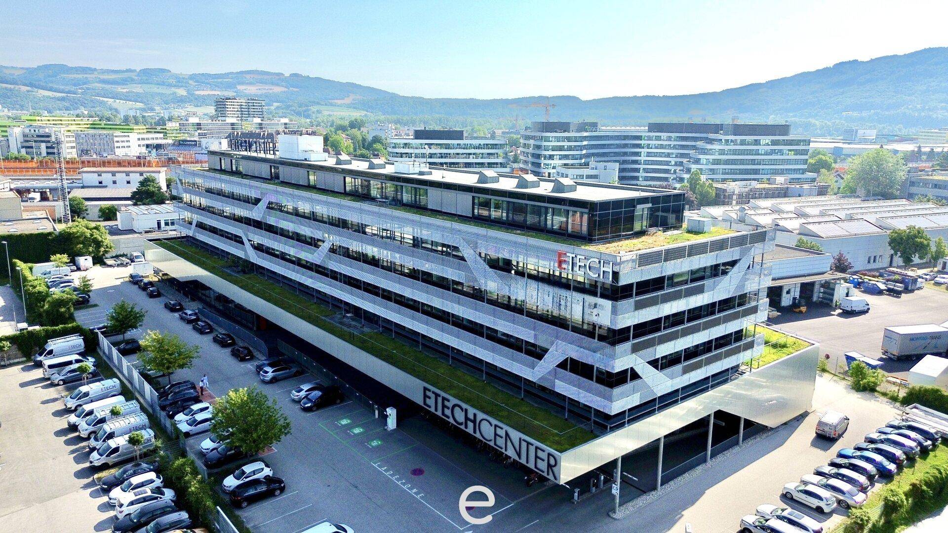 Luftaufnahme des ETECHCENTER-Gebäudes mit begrünten Dächern, Solaranlagen und umliegender Infrastruktur.