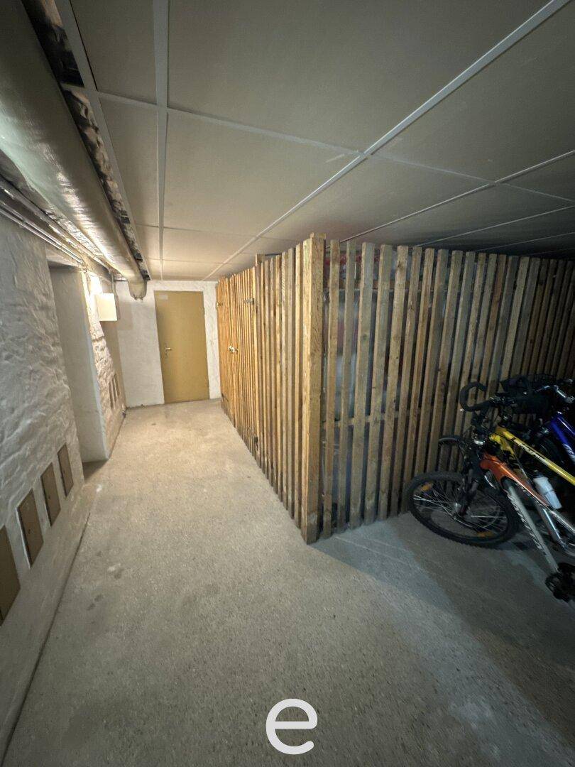 Kellerbereich mit Betonboden, Holzabtrennungen für Stauraum und Abstellmöglichkeiten für Fahrräder.