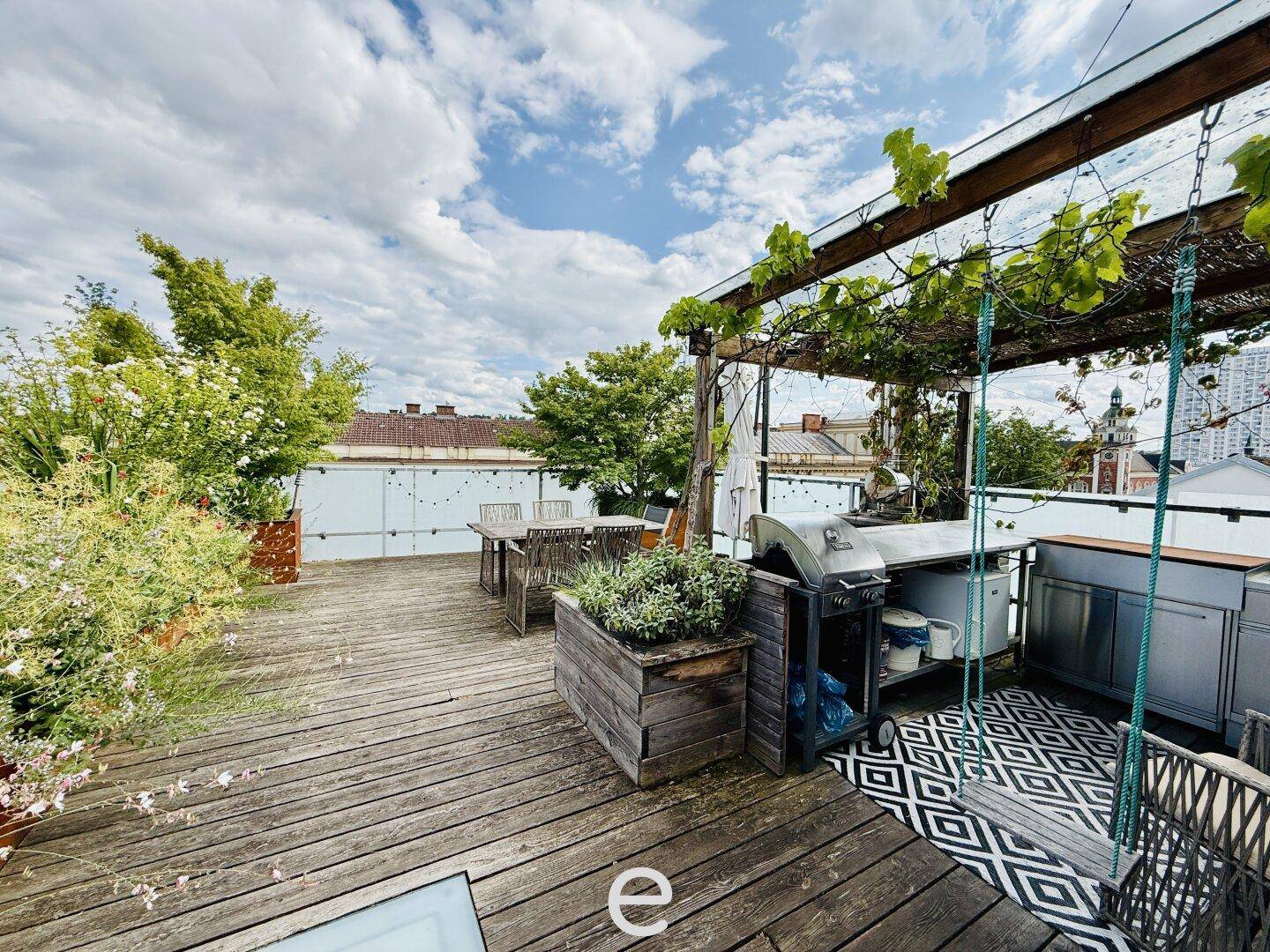 Sonnige Dachterrasse mit Grillbereich, Sitzgelegenheiten und üppiger Bepflanzung.