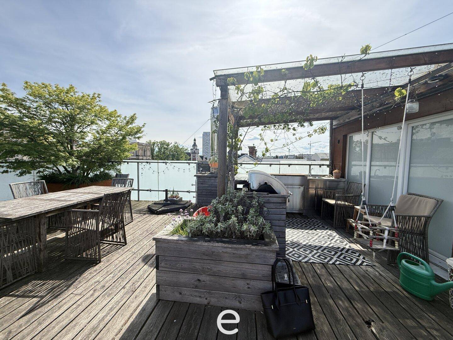Gemütliche Dachterrasse mit Sitzbereich, Pflanzen und Schaukel unter einer Pergola.