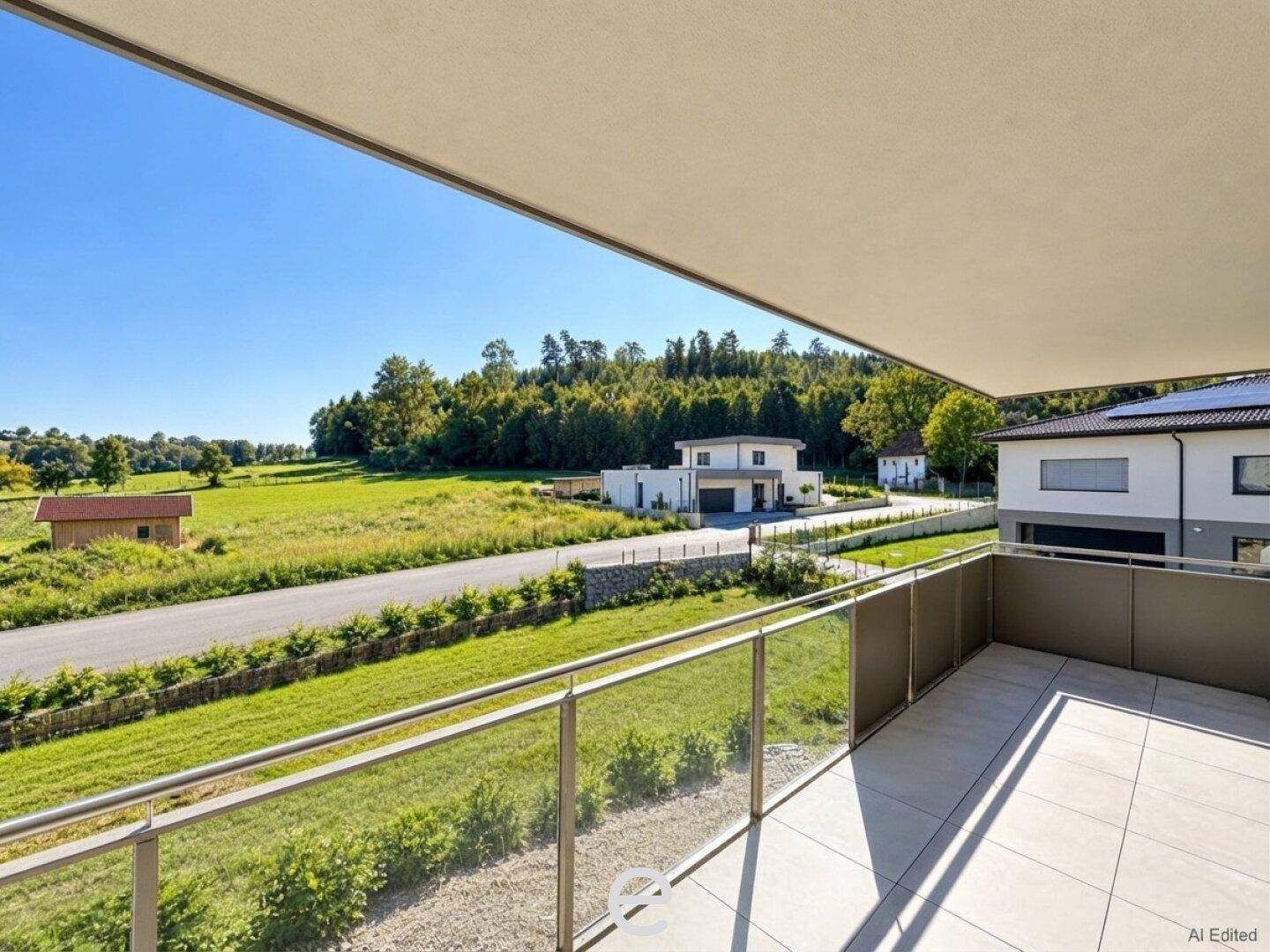 Geräumiger Balkon mit Glasgeländer und weitem Blick ins Grüne und auf die Landschaft.