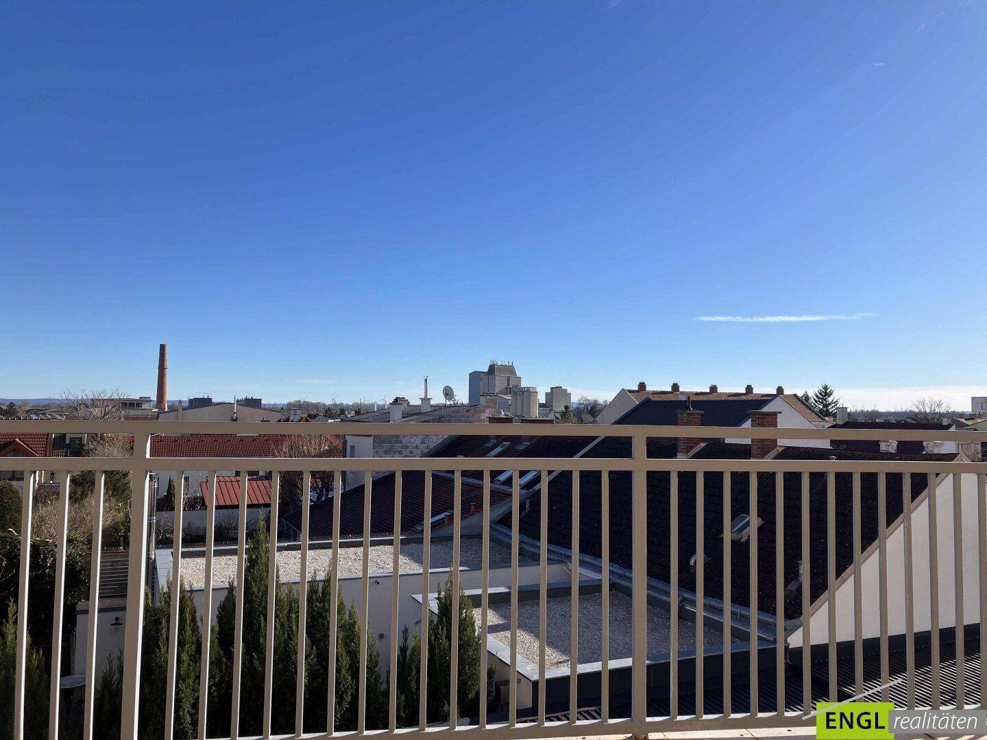 Weitblick über die Dächer der Stadt von einem sonnigen Balkon aus.