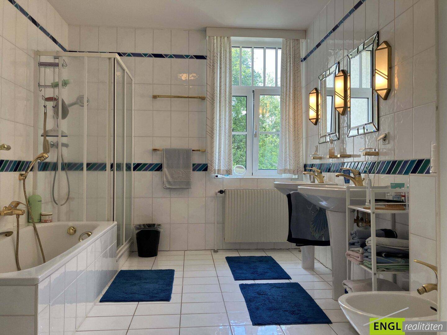 Traditionelles Badezimmer mit weißen Fliesen, Doppelwaschbecken, Badewanne, Dusche und Bidet.