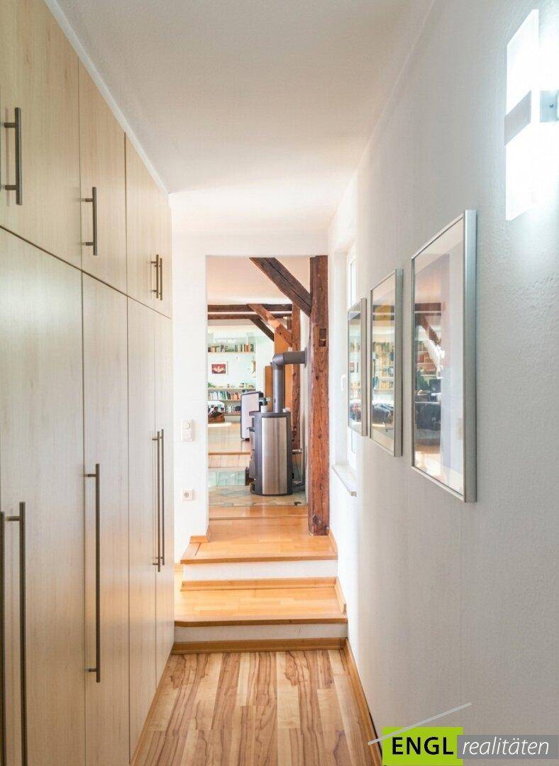 Langer Flur mit praktischen Einbauschränken und Holzfußboden.