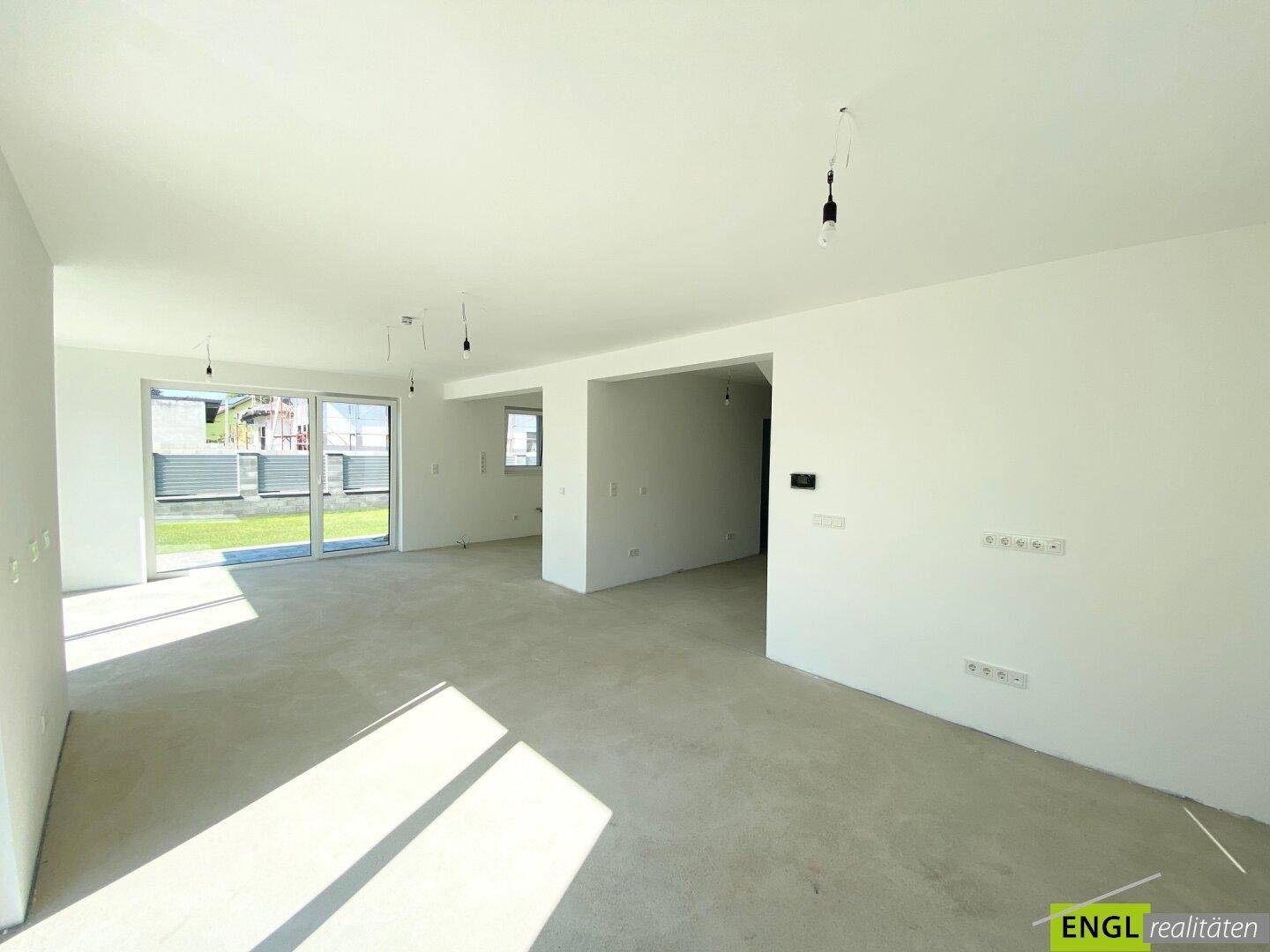 Geräumiger, lichtdurchfluteter Wohnbereich im Neubau mit Blick auf den zukünftigen Garten.