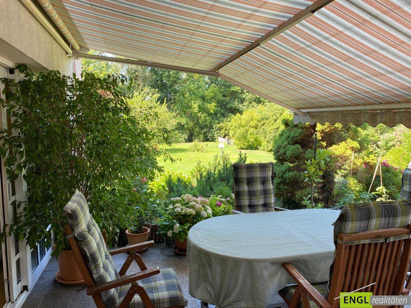Gemütliche überdachte Terrasse mit Gartenmöbeln und Blick ins Grüne, ideal zum Entspannen.