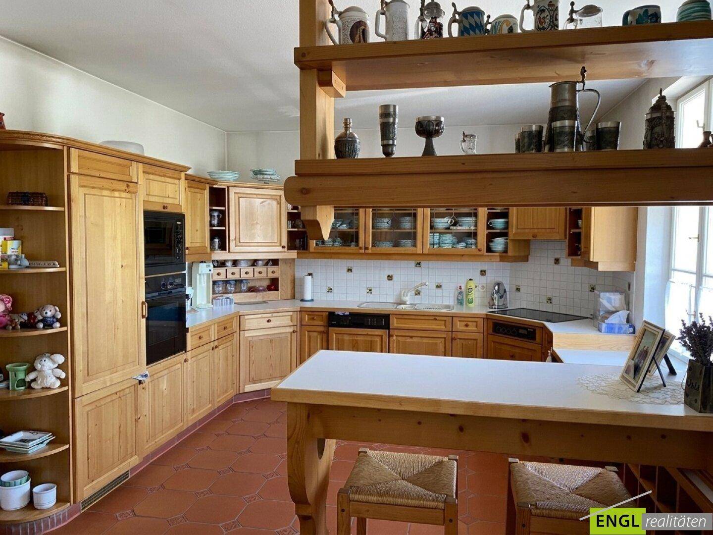 Rustikale Holzküche mit vielen Schränken, integrierten Geräten und traditionellem Charme.