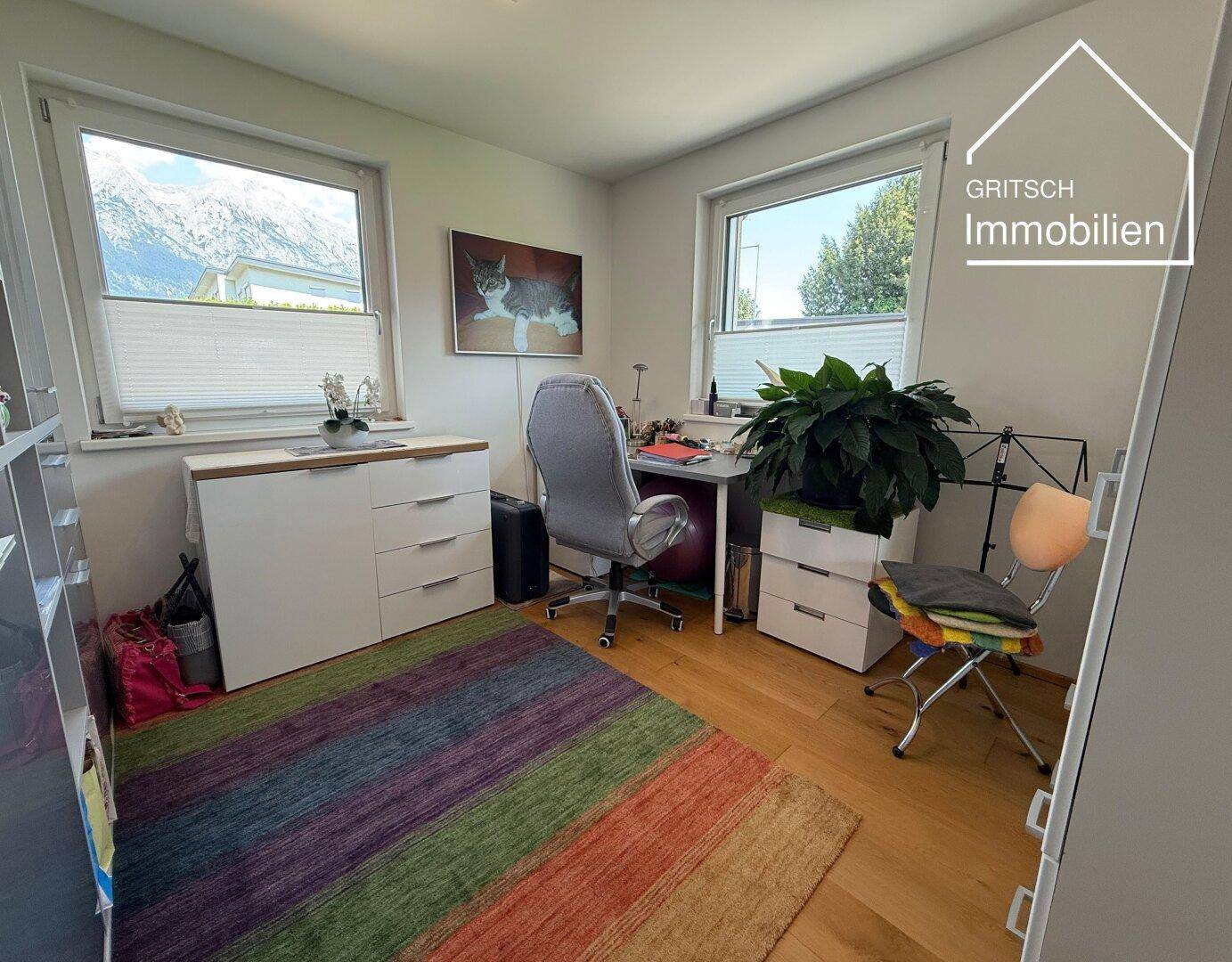 Helles Arbeitszimmer mit Bergblick, zwei Fenstern und funktionaler Einrichtung.