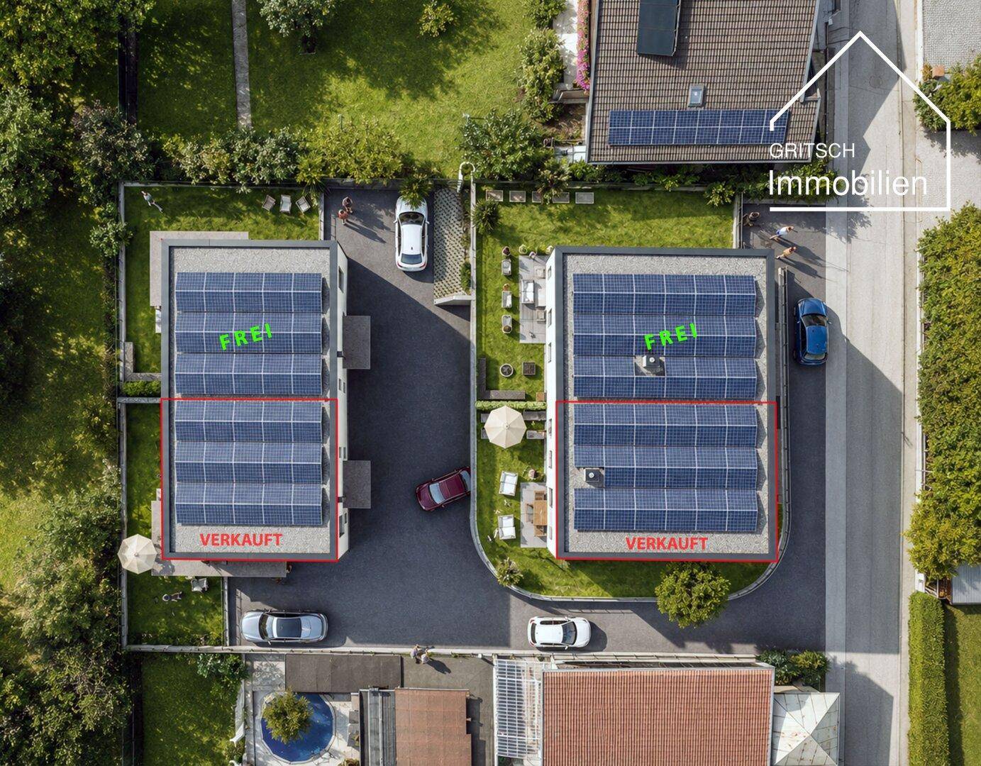 Vogelperspektive auf zwei Wohngebäude mit großen Solaranlagen auf den Flachdächern und Grünflächen.