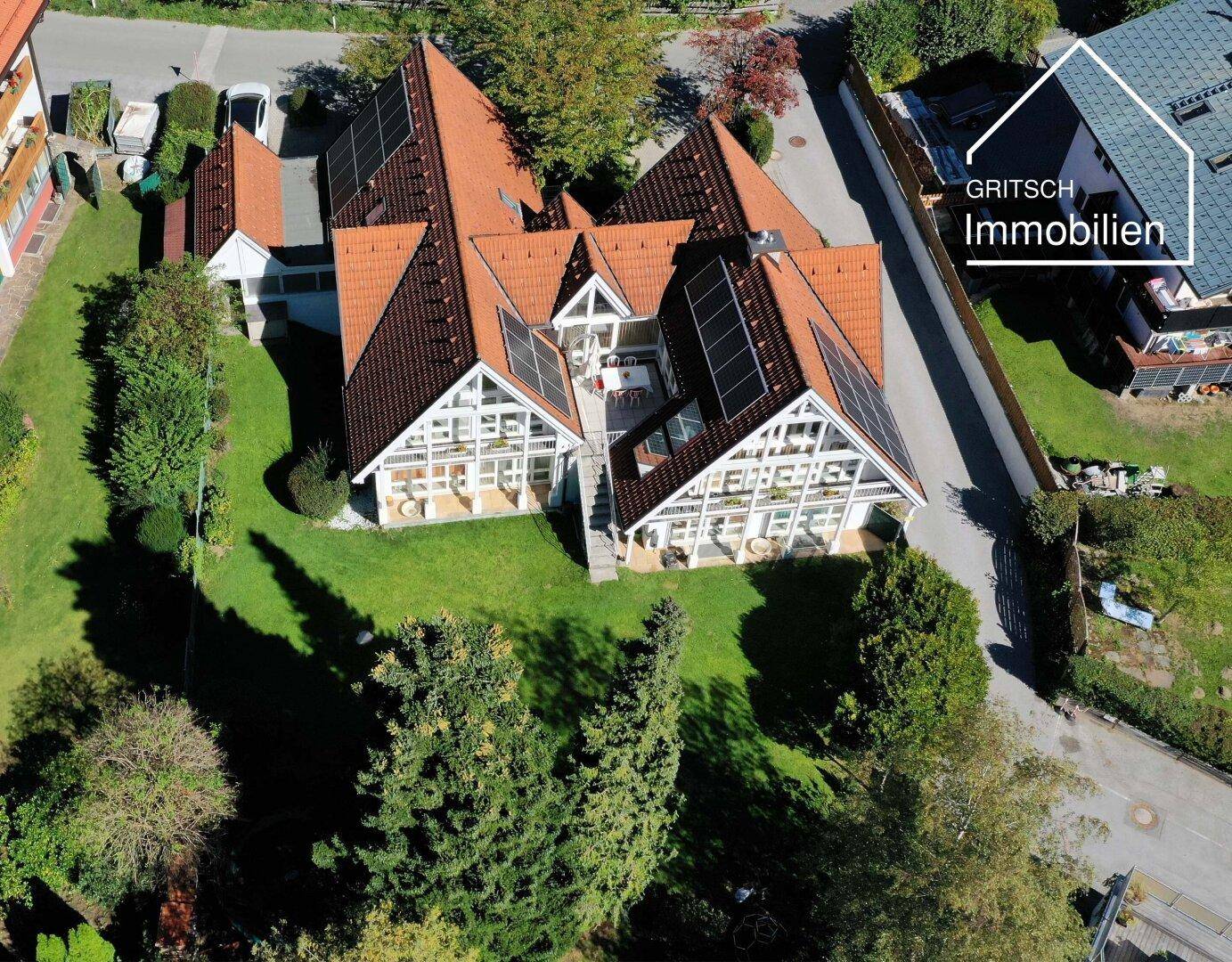 Luftaufnahme des Anwesens mit weitläufigem Garten, rotem Ziegeldach und Photovoltaikanlage.