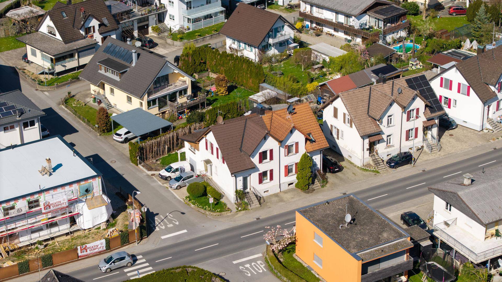 Luftaufnahme einer Wohnsiedlung mit Einfamilienhäusern und Straßen.