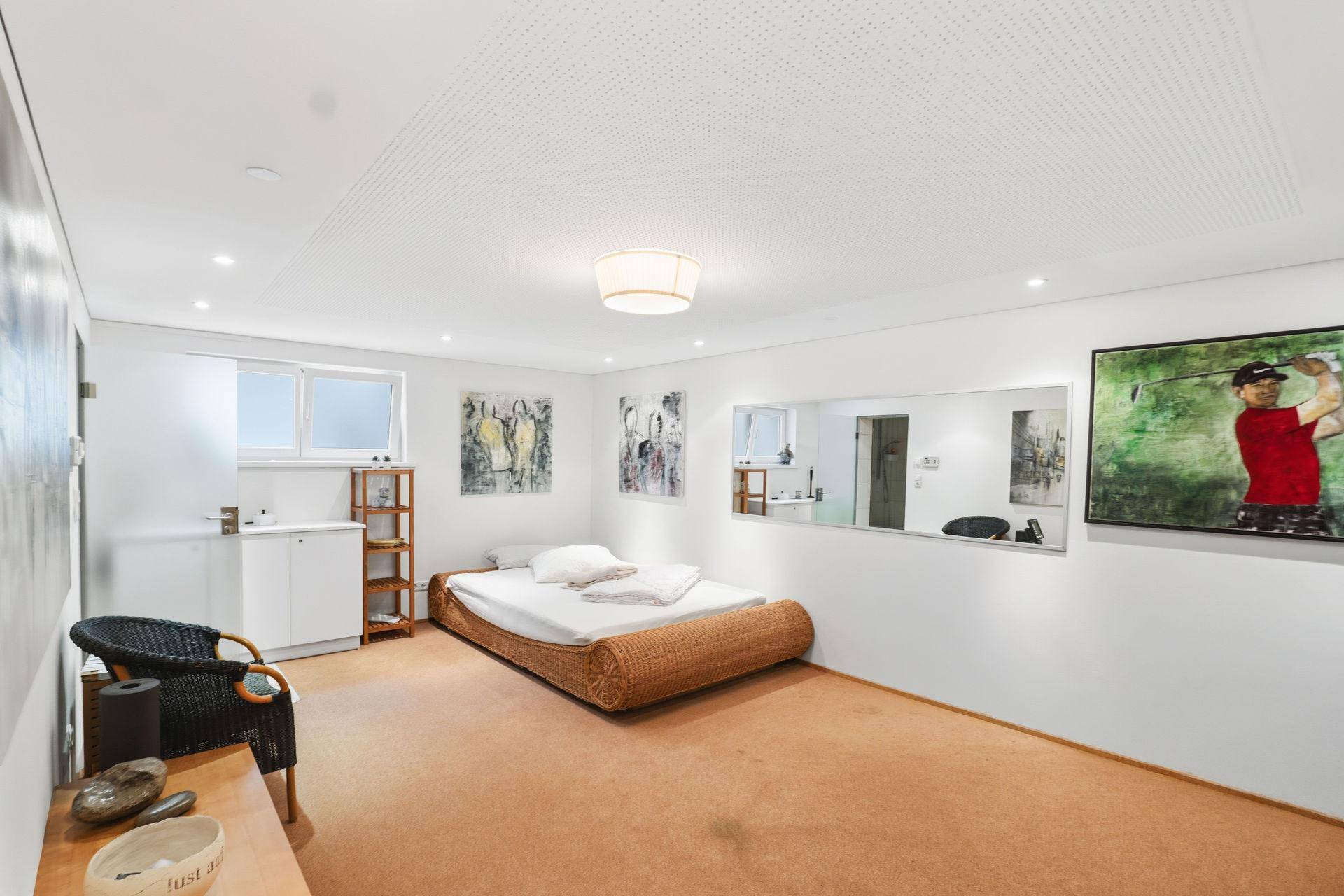 Gemütliches Schlafzimmer im Untergeschoss mit niedrigem Bett und Teppichboden.