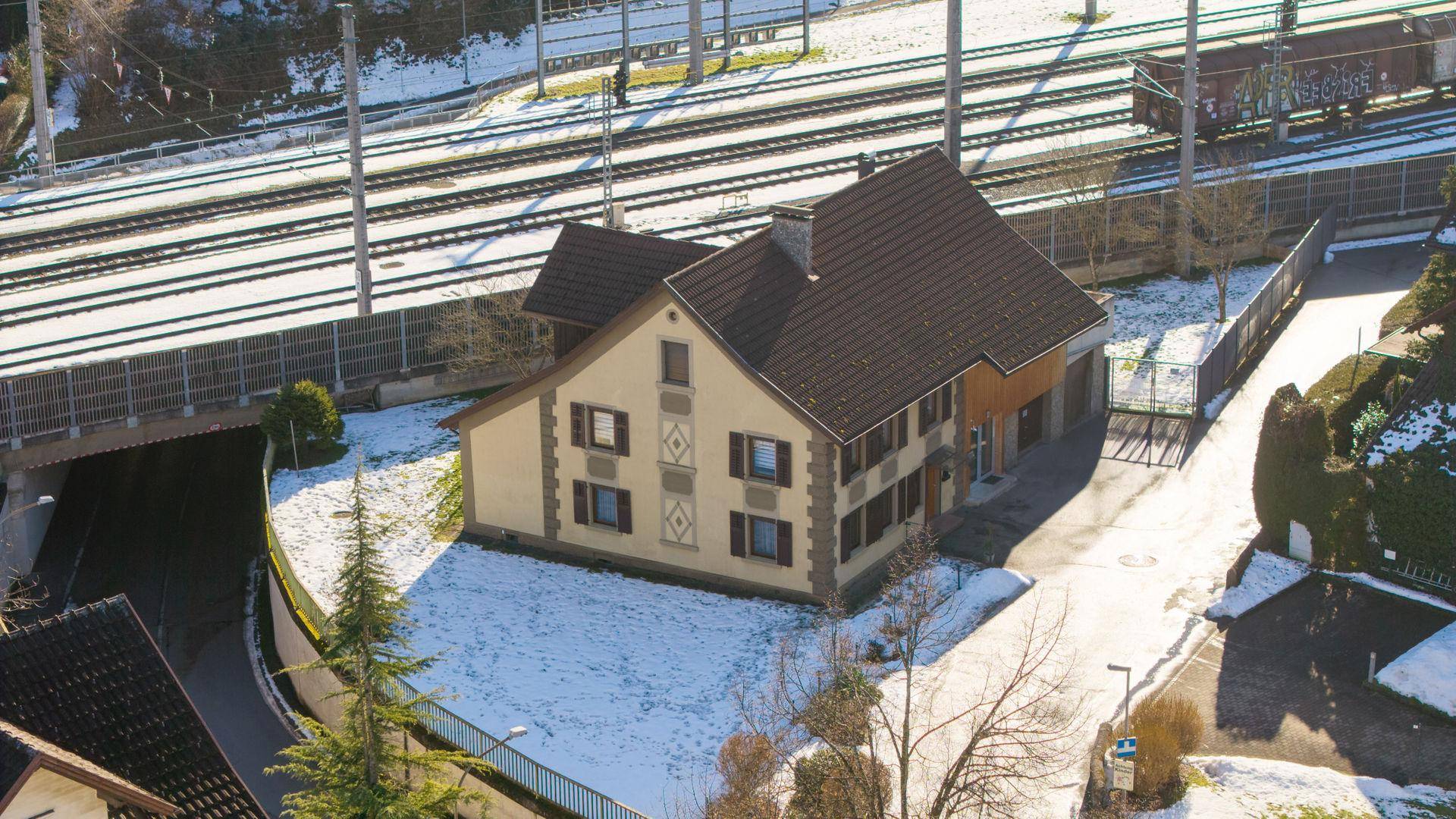 Luftaufnahme eines Hauses mit Satteldach und umliegender Winterlandschaft.