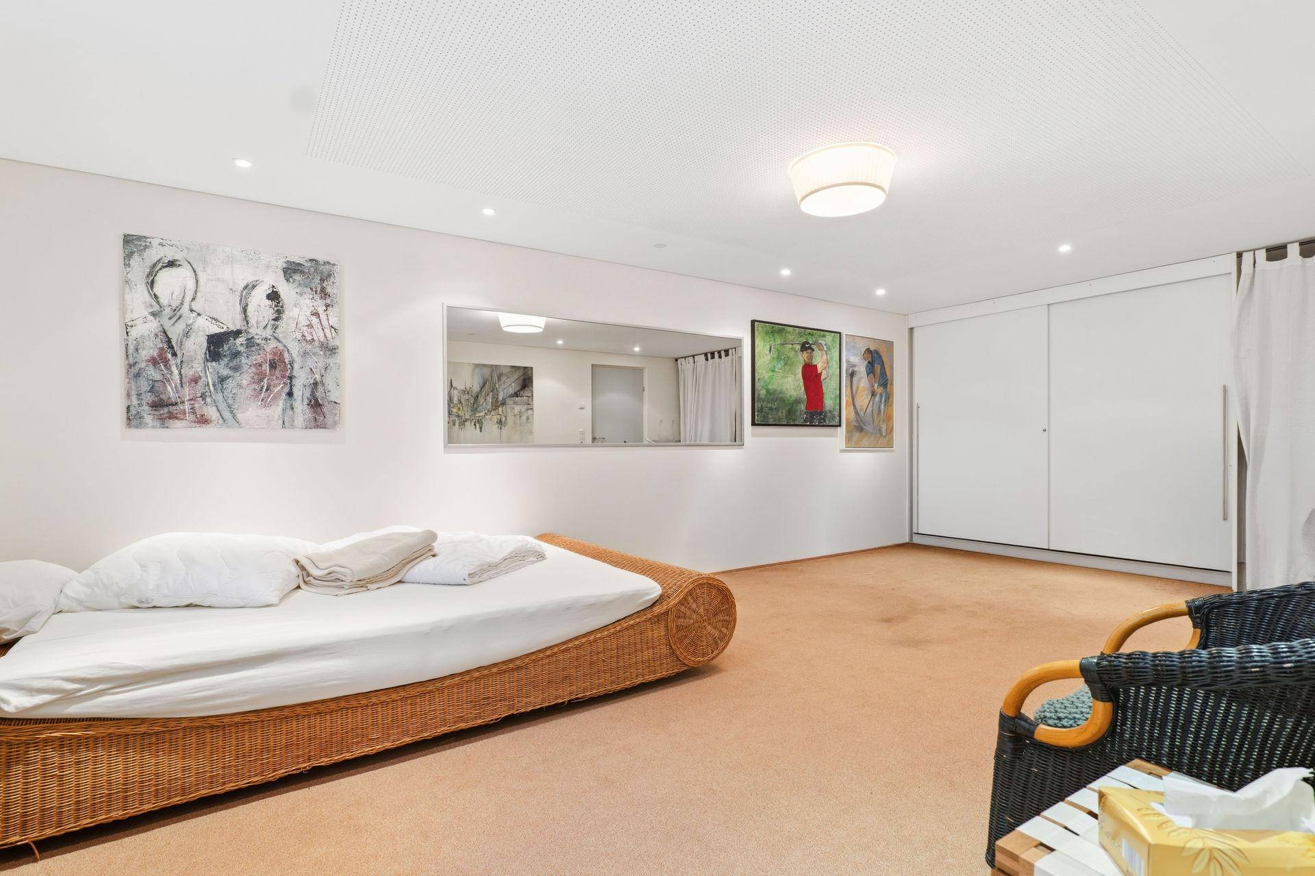Schlafzimmer im Untergeschoss mit integrierten Schränken und Teppichboden.