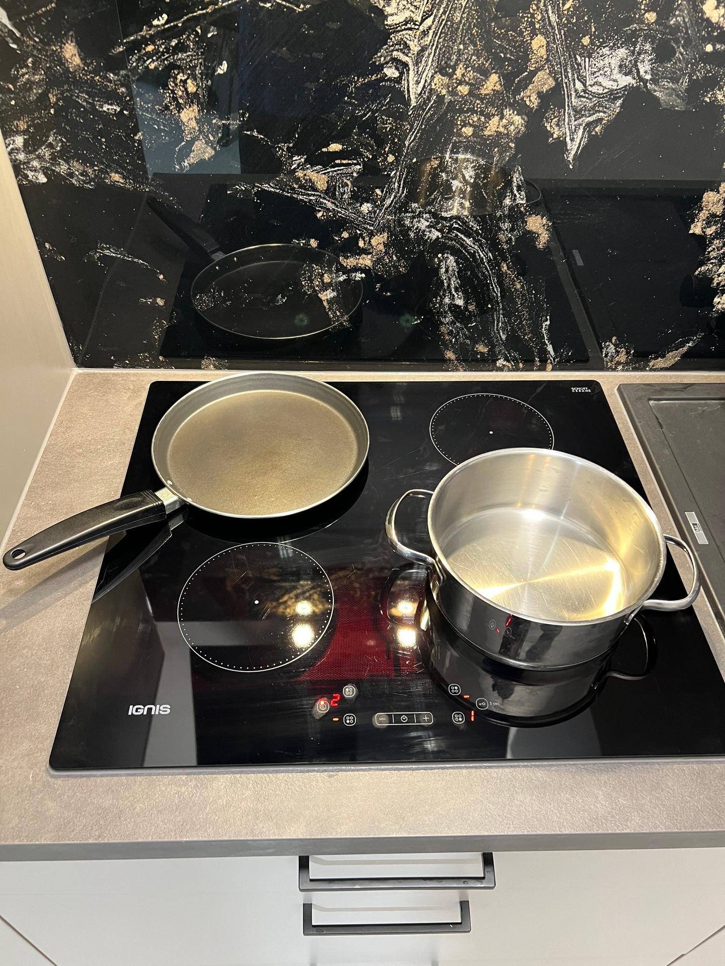 Nahaufnahme des Induktionskochfelds mit zwei Kochfeldern und Kochgeschirr.