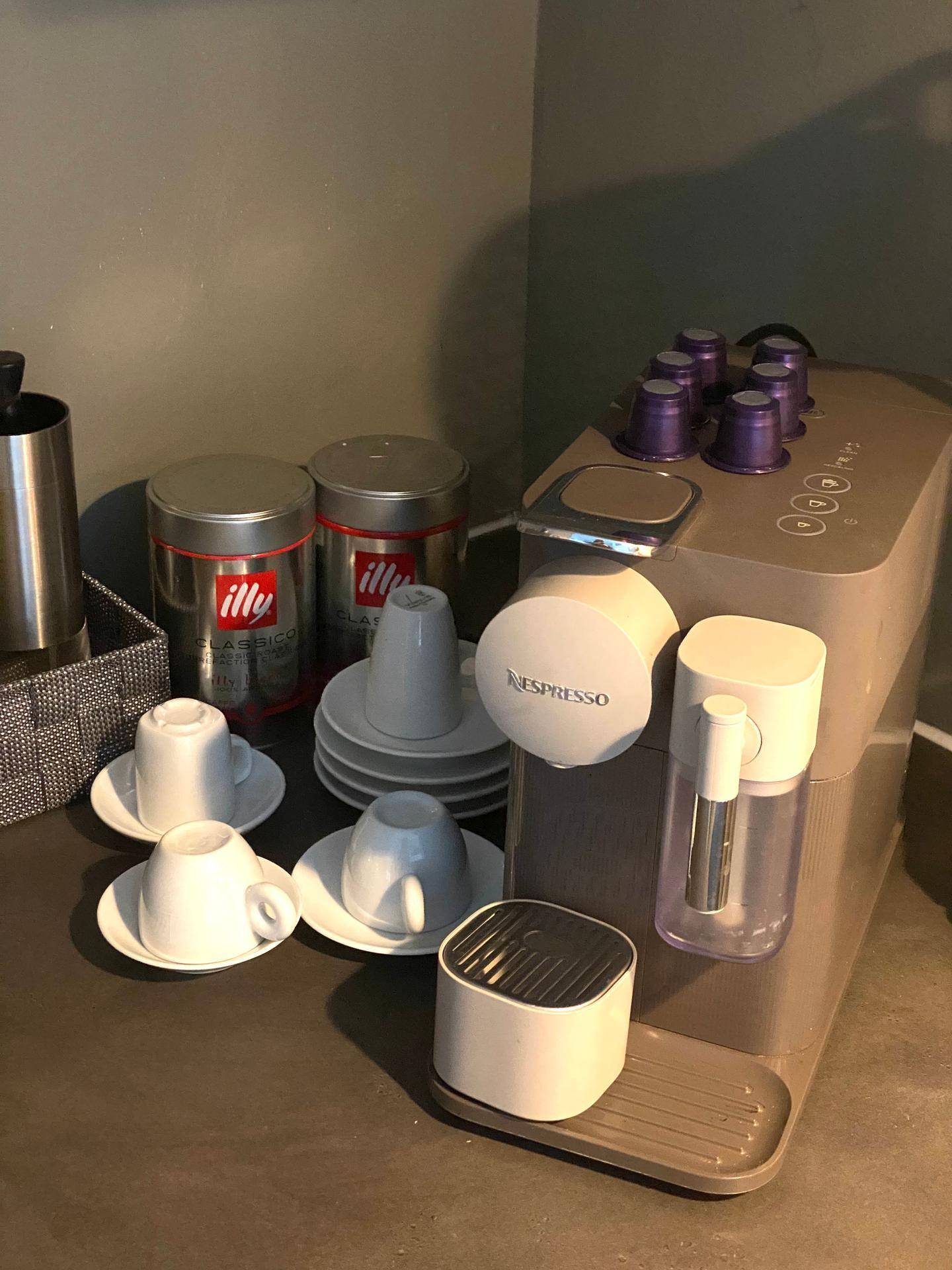 Kaffeemaschine mit Tassen und Kaffeekapseln auf einer Arbeitsplatte in der Küche.