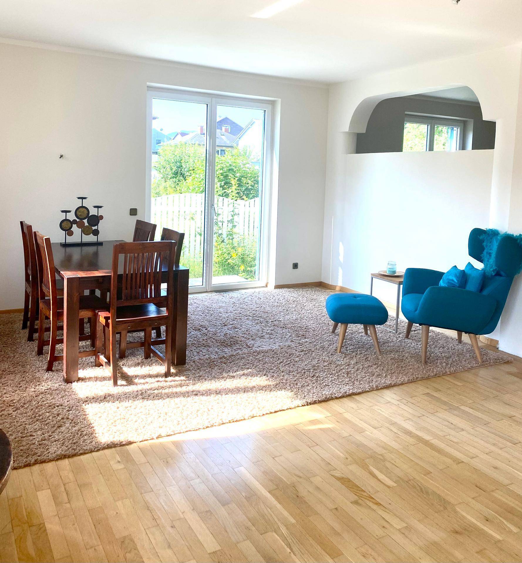 Heller Essbereich mit Holztisch, Stühlen und großem Fenster zum Garten.