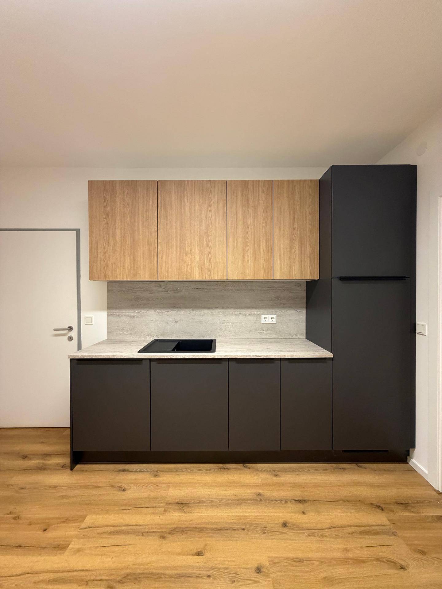 Moderne Einbauküche mit zweifarbigen Schränken, heller Arbeitsplatte und Induktionskochfeld.