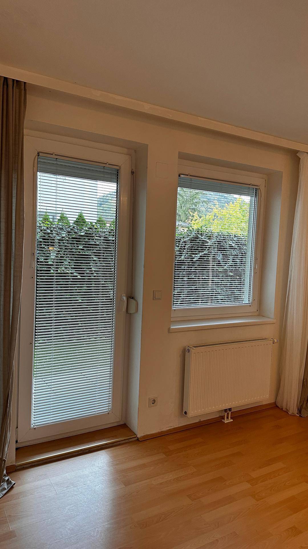 Fenster und Fenstertür mit geschlossenen Jalousien bieten Privatsphäre.