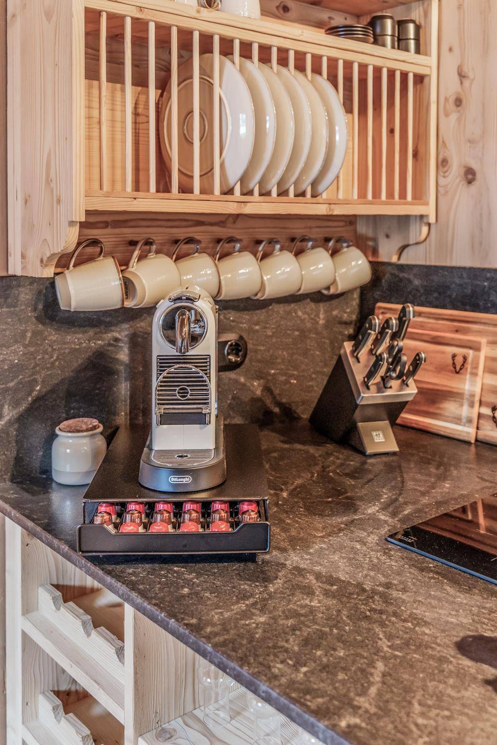 Küchenarbeitsplatte mit Kaffeemaschine, Messerblock und praktischem Geschirrregal aus Holz.