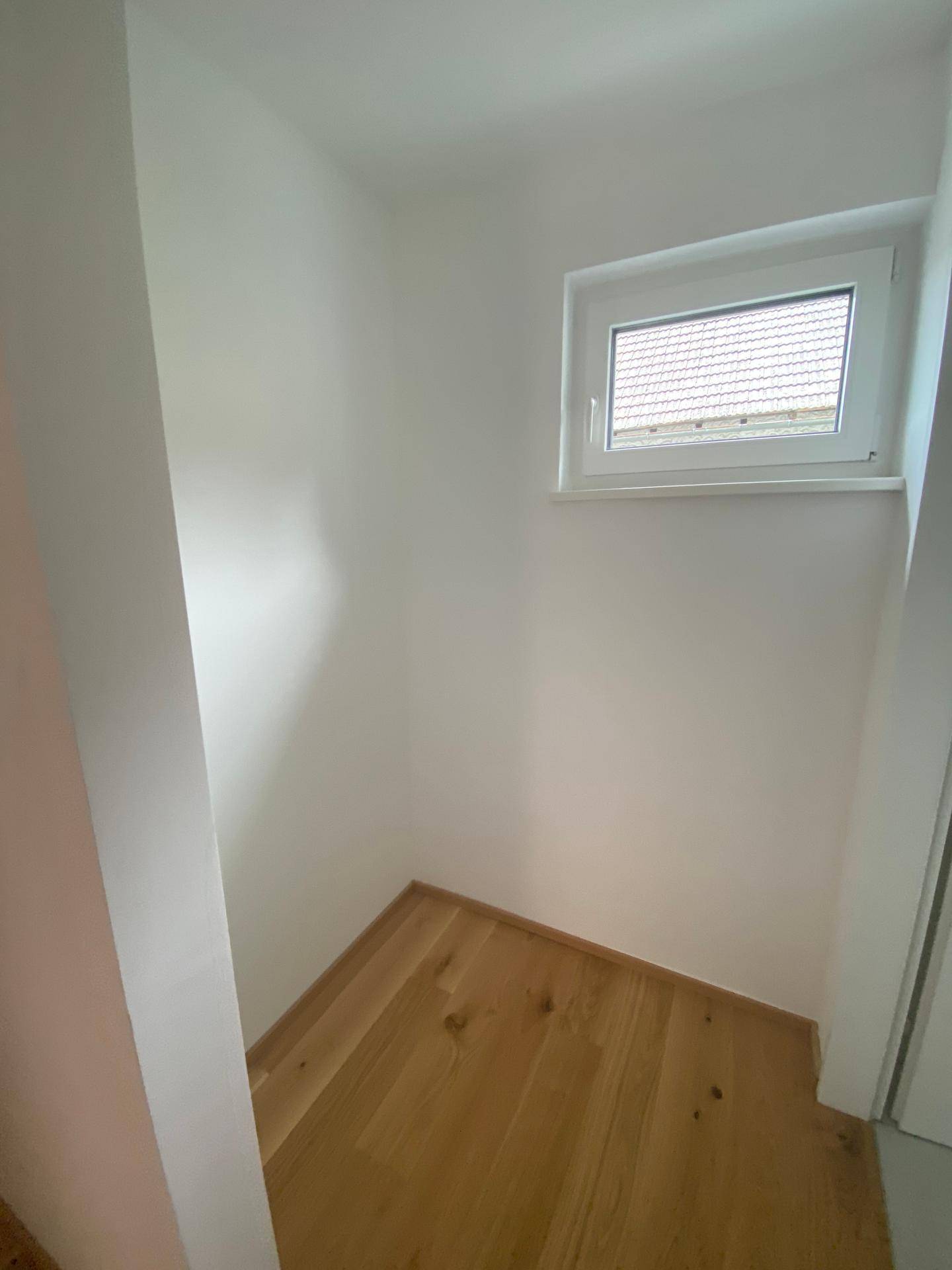 Kleiner Raum mit Fenster und Holzboden, ideal als Abstell- oder Hauswirtschaftsraum.