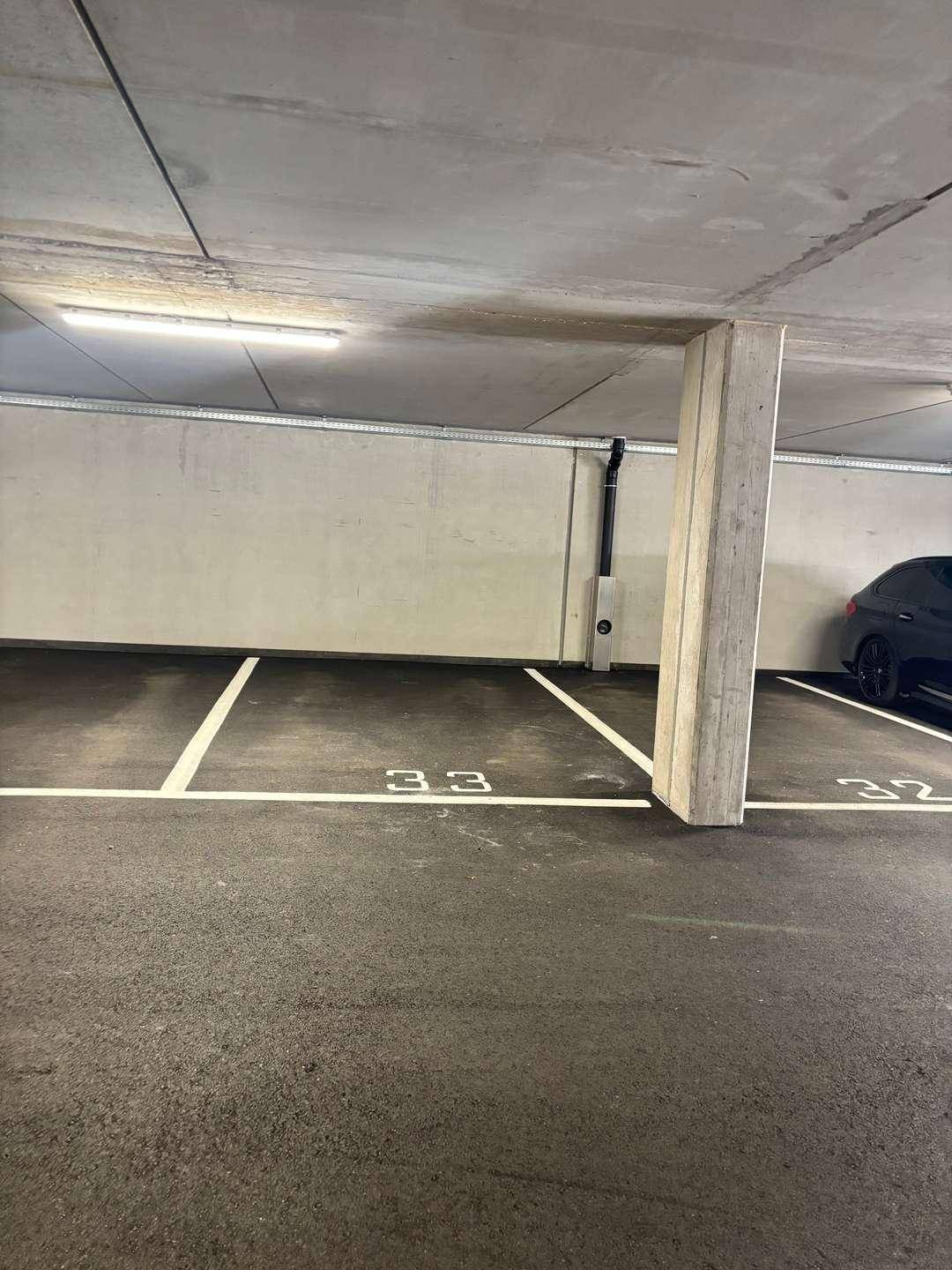 Tiefgarage mit markierten Stellplätzen und moderner Beleuchtung.
