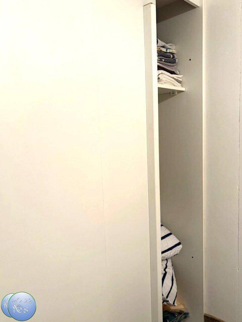 Schmaler Einbauschrank mit Regalböden für Wäsche oder persönliche Gegenstände.