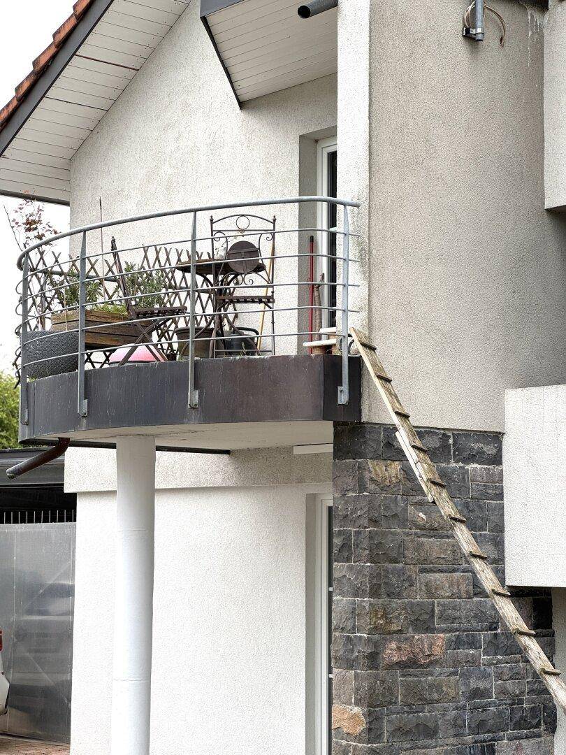 Gemütlicher Balkon mit Metallgeländer und Sitzgelegenheiten, ideal für entspannte Stunden im Freien.