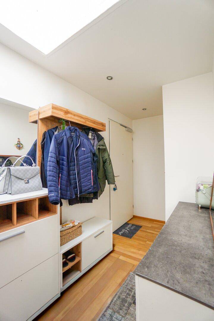 Eingangsbereich mit Garderobe, Holzdetails und hellem Parkettboden.