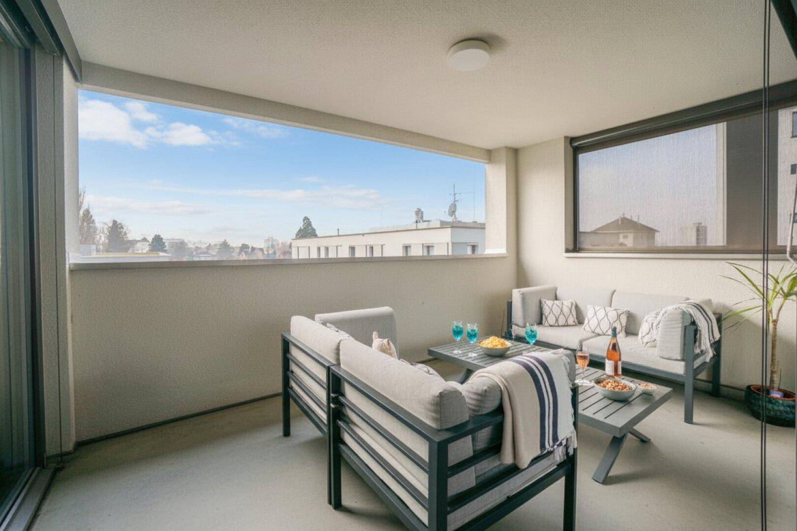 Geräumiger Balkon mit bequemen Loungemöbeln und weitem Blick über die Umgebung.