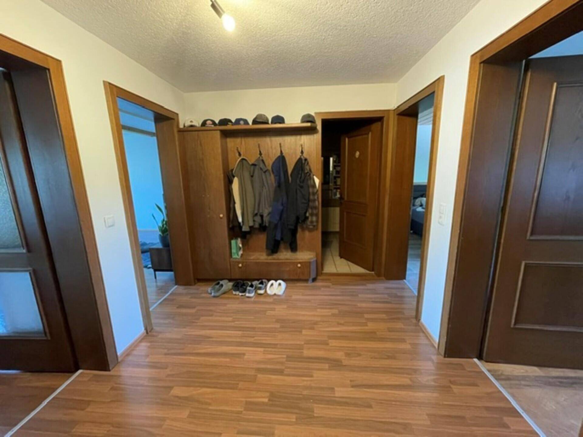 Flur mit praktischer Garderobe und Laminatboden, der zu verschiedenen Räumen führt.
